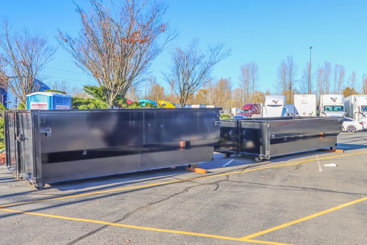 Professional dumpster rental service with roll-off container on residential driveway in Battlefield
